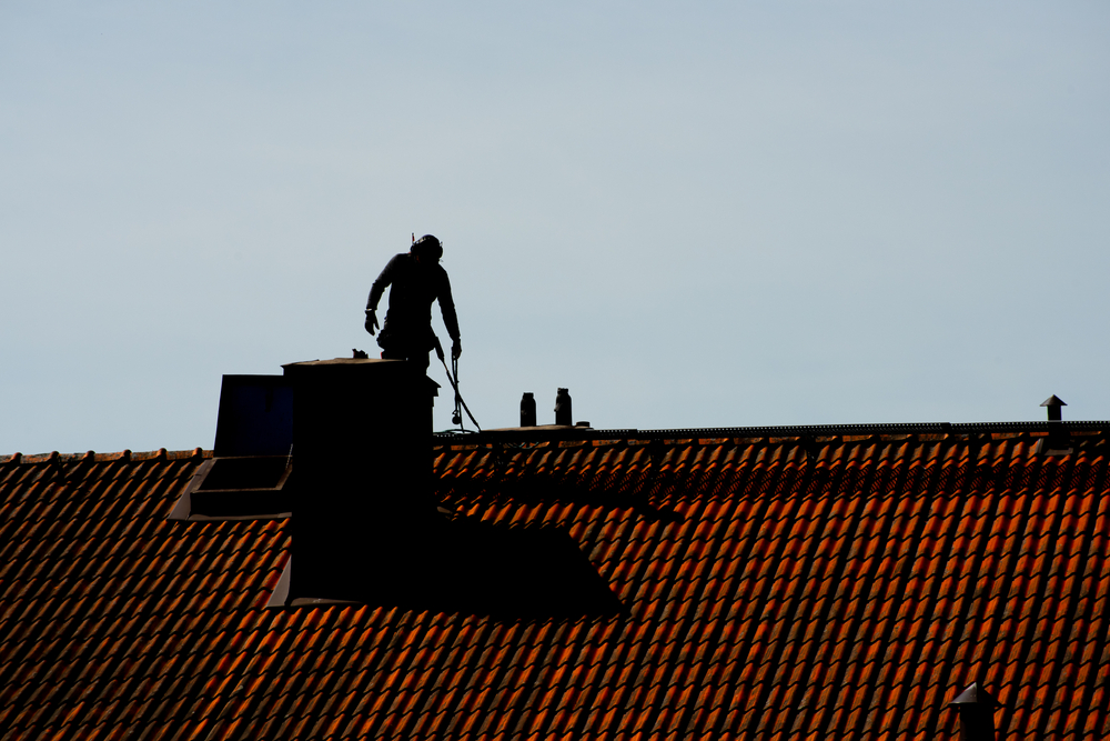 Silhouette,Of,A,Chimney,Sweeper,On,Top,Of,A,Roof.