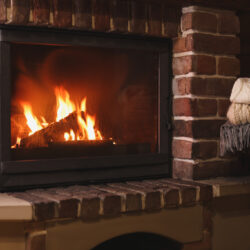 Stack,Of,Knitwear,Near,Fireplace,With,Burning,Wood,Indoors.,Winter
