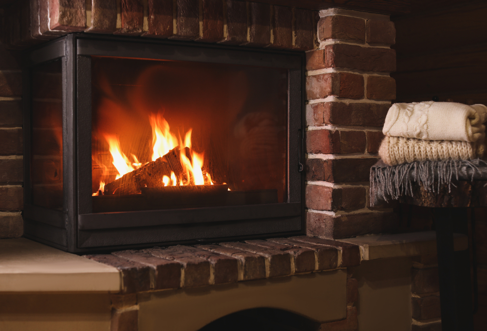 Stack,Of,Knitwear,Near,Fireplace,With,Burning,Wood,Indoors.,Winter